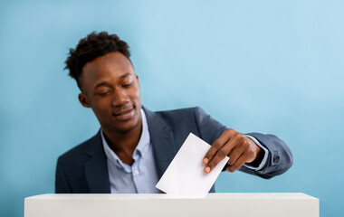 African american man pulls envelope into vote ballot