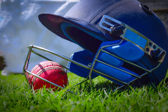 Cricket ball and halmet isolated on a grass. World cup cricket concept and are important equipments for cricket.