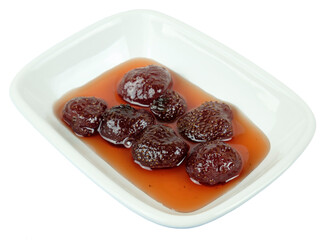 Strawberry jam in the white porcelain plate on a white background