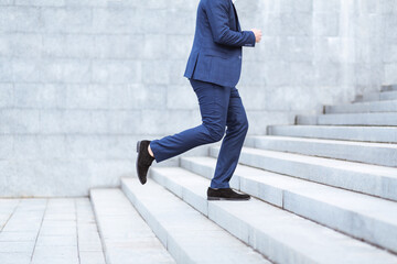 Closeup view of entrepreneur running up stairs, being late for work in busy city