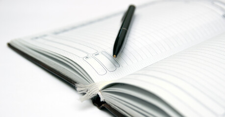 Open notebook with a pen, horizontal.
