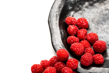 Fresh raspberries on a black plate