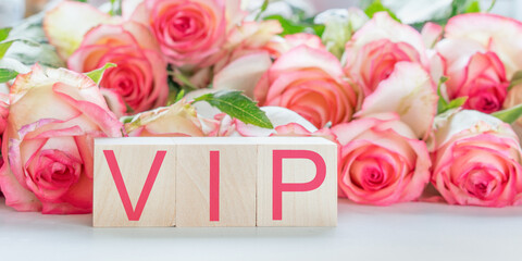 vip sign by red letters on wooden blocks rose flowers background hotel service concept
