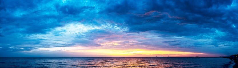Naklejka na ściany i meble Beautiful sunset with colored clouds over the sea