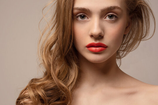 Young woman with perfect skin. Studio portrait. Closeup. Red lips. Girl with beautiful hair.