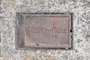 metal cover on the pavement of the drinking water service