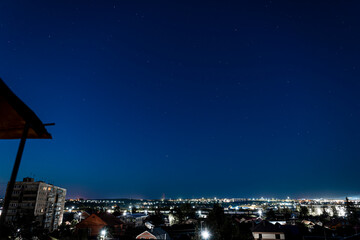 The starry blue sky above a provincial Russian city at night. Cityscape and space.