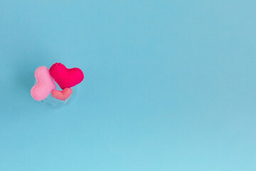 Three felt handmade pink hearts are on a blue background. The concept of the family, Valentines...