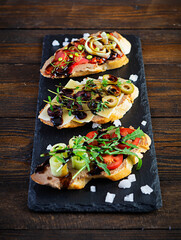 Bruschetta with chicken liver paste. Delicious bruschettas with various fillings. Different bruschetta ob wooden background