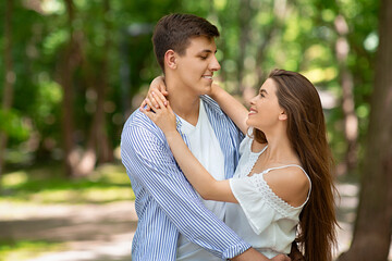 Fototapeta premium Young married couple embracing each other outside on warm summer day, free space