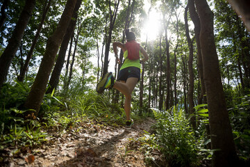 Young woman trail runner running in tropical forest