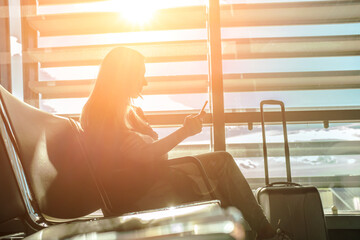 Woman waiting aircraft in airport. Young Female tourist traveling