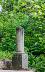 Fototapeta na wymiar old stone column in the green park 