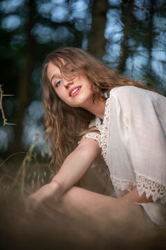 Beautiful young girl wearing a lace top posing in a dark forest