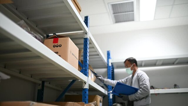 Technician check stock at the store,working and wear mask for protect Covid-19,engineer counting equipment in the lab.
