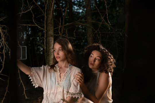 Beautiful girls posing together on forest background