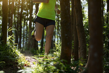 Young woman trail runner running in tropical forest