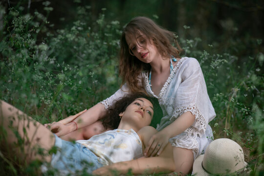 Beautiful girls posing together on forest background