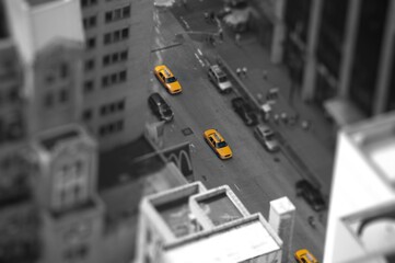 High angle view of yellow taxis with grayscale city buildings