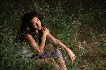 Beautiful young woman posing in a dark forest 