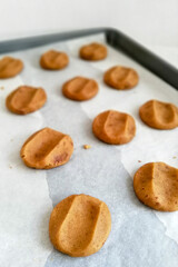 cookie dough cookies on a baking tray with white parchment paper 