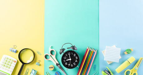 Education or back to school Concept. Top view of Colorful school supplies with books, color pencils, calculator, pen cutter clips and green apple on pastel paper  background. Flat lay.
