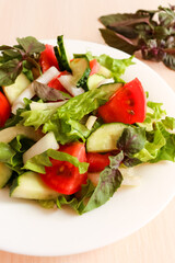  Salad with cucumbers, tomatoes, salad, pepper and basil. Home made food. Concept for a tasty and healthy meal.