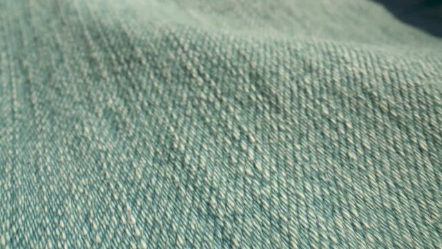 Extreme close-up along blue, denim fabric.