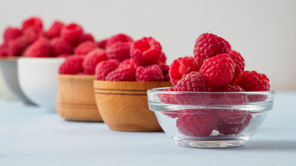 Assorted fresh raspberry in different plates.