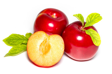 Plum fruits with green leaves and slice isolated on white