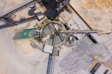 Aerial view of a large Quarry during work hours with Stone sorting conveyor belts and an open pit mine.