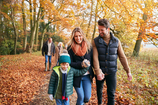 Multi-Generation Family Enjoying Walk Along Autumn Woodland Path Together