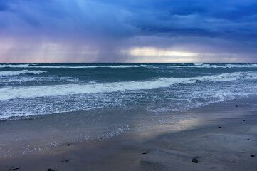 Sunset over the sea. Reflection of sunlight in the sea waves. The sky in the sunset rays.