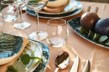 Beautiful elegant table setting with green stylish dishware and silver cutlery