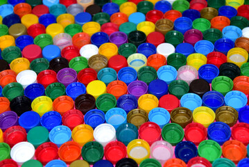 Plastic bottle caps background. Waste cap material is recyclable. Plastic lids from HDPE for recycle. Recycling plastic bottle caps.