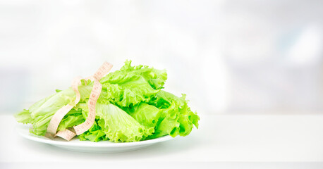 
Fresh lettuce leaves wrapped in a centimeter on a white table