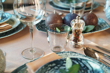 Beautiful elegant table setting with green stylish dishware and silver cutlery