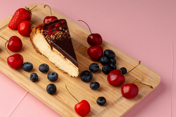 Naklejka na ściany i meble Piece of cheesecake with chocolate top and berries