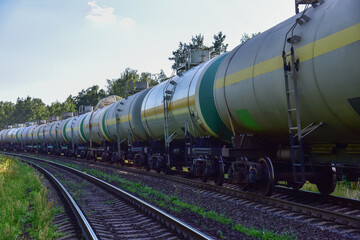 Fototapeta na wymiar Transport tank car LNG by rail, gas - oil products. LPG transport propane. The fuel train, rolling stock with petrochemical tank cars. Liquefied natural gas export.