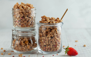 Homemade granola in different glass jars with strawberries. The concept of a quick Breakfast, a healthy diet. Copy space