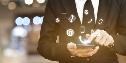 CONTACT US. Businessman hand using mobile smartphone with (phone, mail, address) icon.