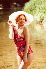 Porträt einer Frau im Badeanzug, die im Wasser steht und in die Kamera schaut