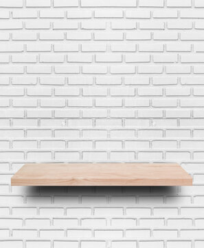 Empty wooden shelf on white brick wall background.