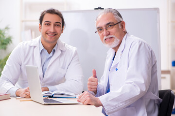 Experienced doctor teaching young male assistant