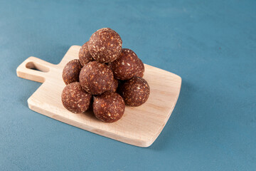 Healthy homemade sweets on a wooden serving board. Energy balls laid out in the form of a pyramid....
