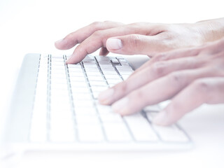 Hands typing on remote control wireless computer keyboard.