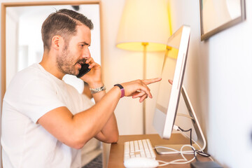 Fototapeta premium A young Caucasian man telecommuting at home on the computer, a new normal after the Coronavirus pandemic, covid-19. Work video call.