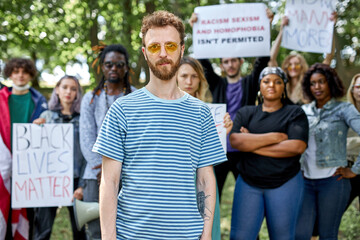 young caucasian american guy is leading the group of BLM protestors. stop racism concept. people agitate to be tolerant and friendly