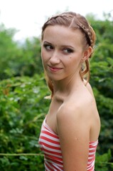 The beautiful girl is walking outdoors. Girl in the park. Girl on nature. Woman outside. Positive woman smiling