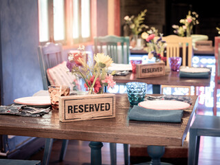 Wooden reserved sign on dining table in restaurant.
